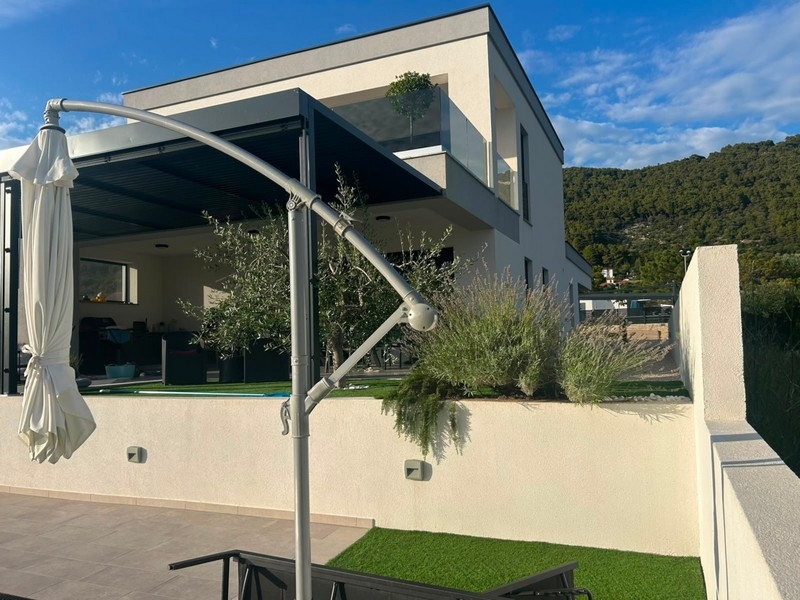 Überdachte Terrasse mit Sonnenschirm am Neubauhaus auf Rab