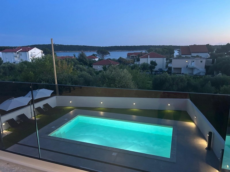 Beleuchteter Pool mit Blick über Banjol und die Bucht