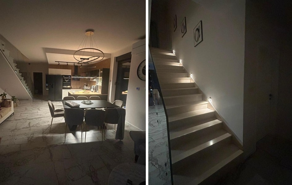 Wohnbereich mit offener Küche und beleuchtete Treppe