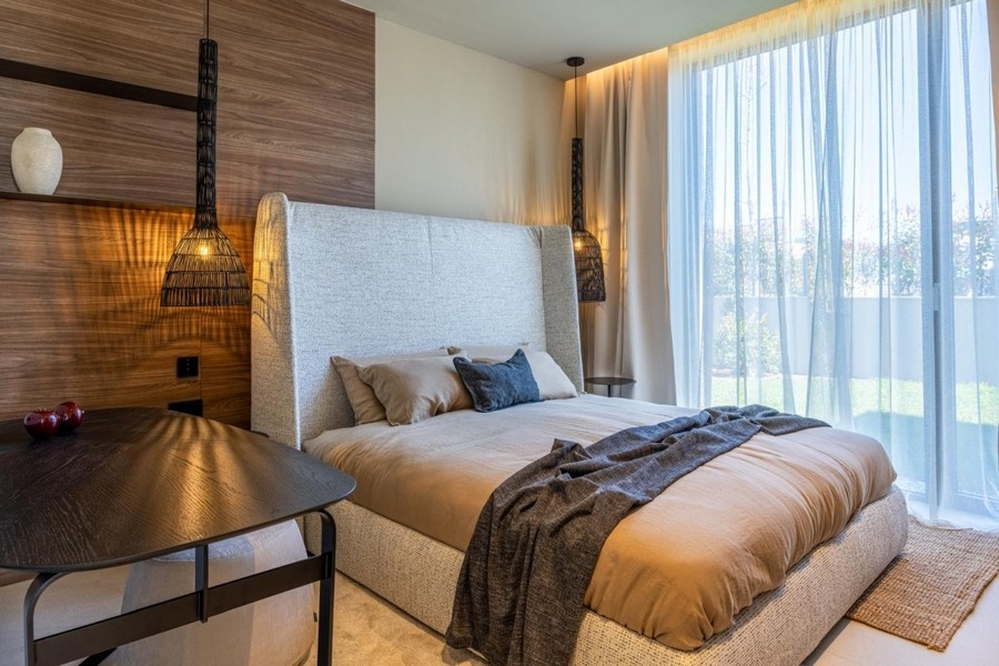 Schlafzimmer mit gepolstertem Bett und Holzwand in Kroatien