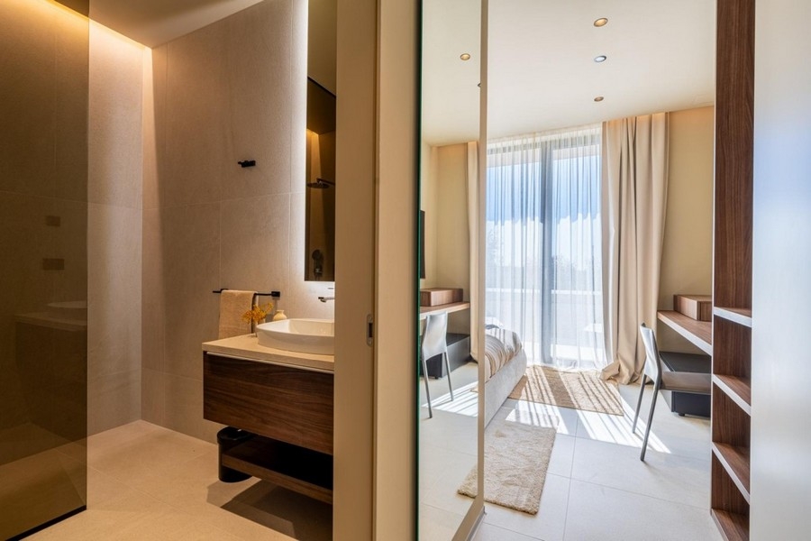 Badezimmer mit Waschtisch und Blick ins Schlafzimmer