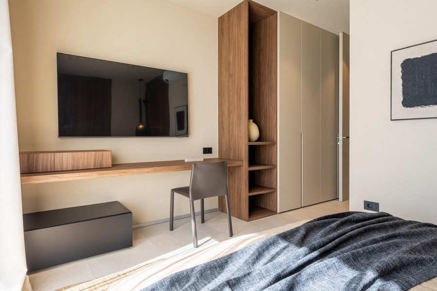 Schlafzimmer mit Schreibtisch, TV und Einbauschrank