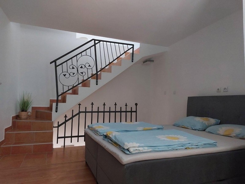 Schlafzimmer mit Doppelbett und Treppe