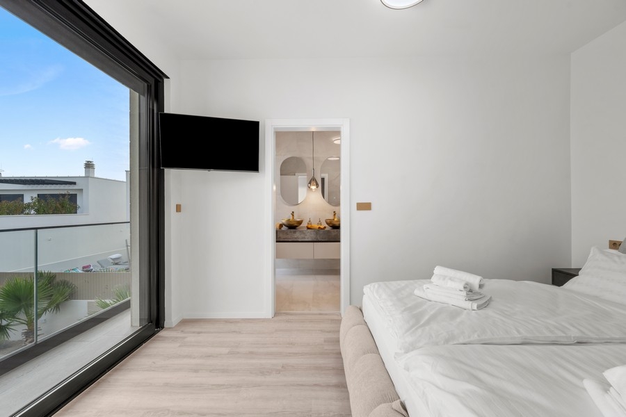 Schlafzimmer mit Fernseher und eigenem Bad