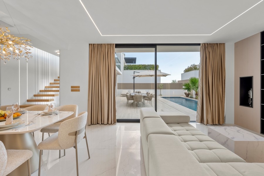 Wohnzimmer mit Sofa und Zugang zur Poolterrasse