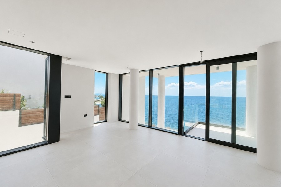 Raum mit Glasfront und Terrasse mit Meerblick