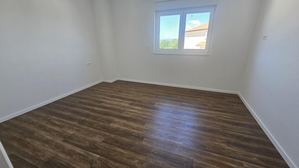 Schlafzimmer mit Fenster und Holzboden