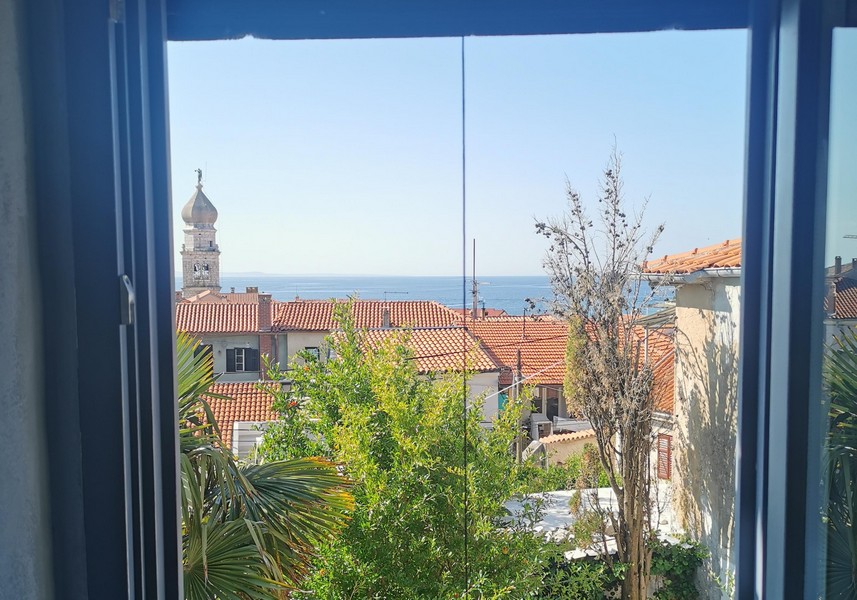 Fensterblick auf das Meer und die Altstadt von Krk mit Kirchturm