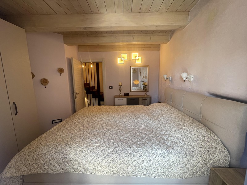 Schlafzimmer mit Doppelbett und Holzbalkendecke