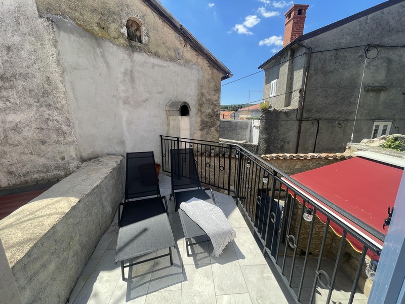 Terrasse mit Liegestühlen und Blick über die Dächer von Krk