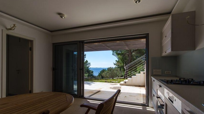 Essbereich mit Blick durch die Terrassentür auf das Meer