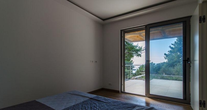 Schlafzimmer mit großer Glasschiebetür ins Freie