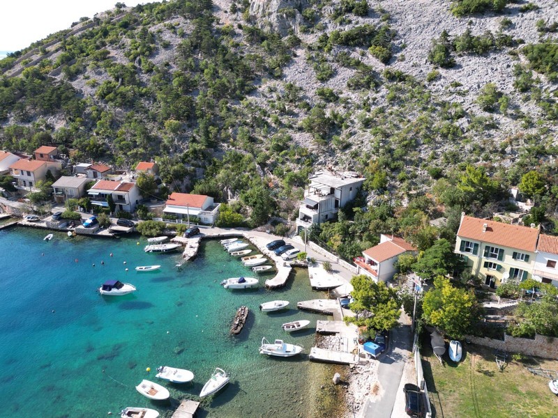 Luftaufnahme der Bucht mit Booten und Haus in erster Reihe zum Meer bei Senj