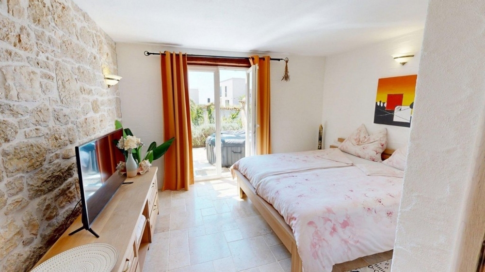 Schlafzimmer mit Doppelbett und großem Fenster