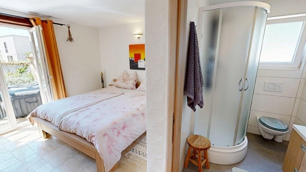 Schlafzimmer mit Doppelbett und Zugang zum Bad
