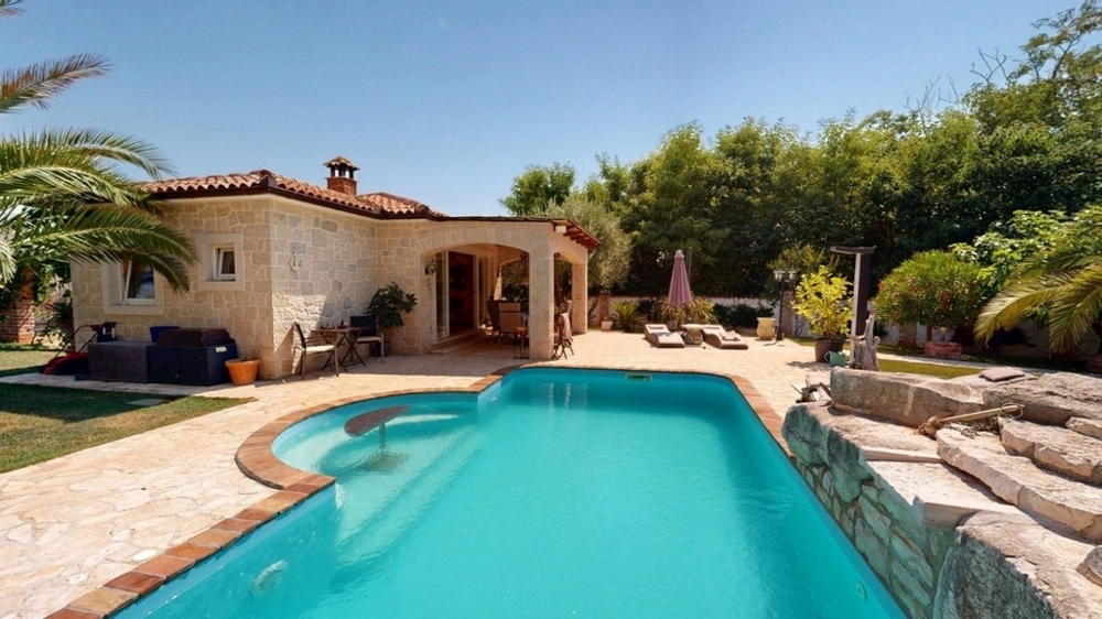 Swimmingpool mit Sonnenterrasse und Blick zum Haus