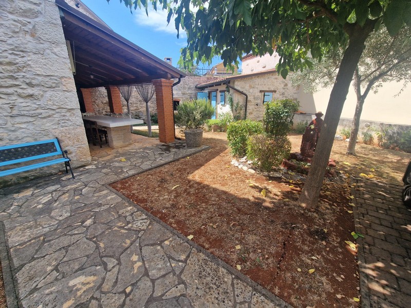 Überdachte Terrasse und Garten des Steinhauses