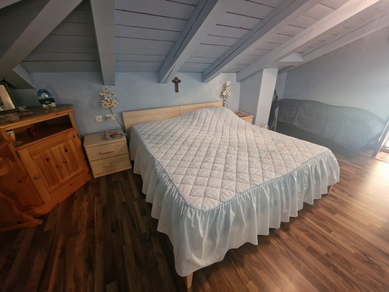 Schlafzimmer mit Doppelbett und Holzboden
