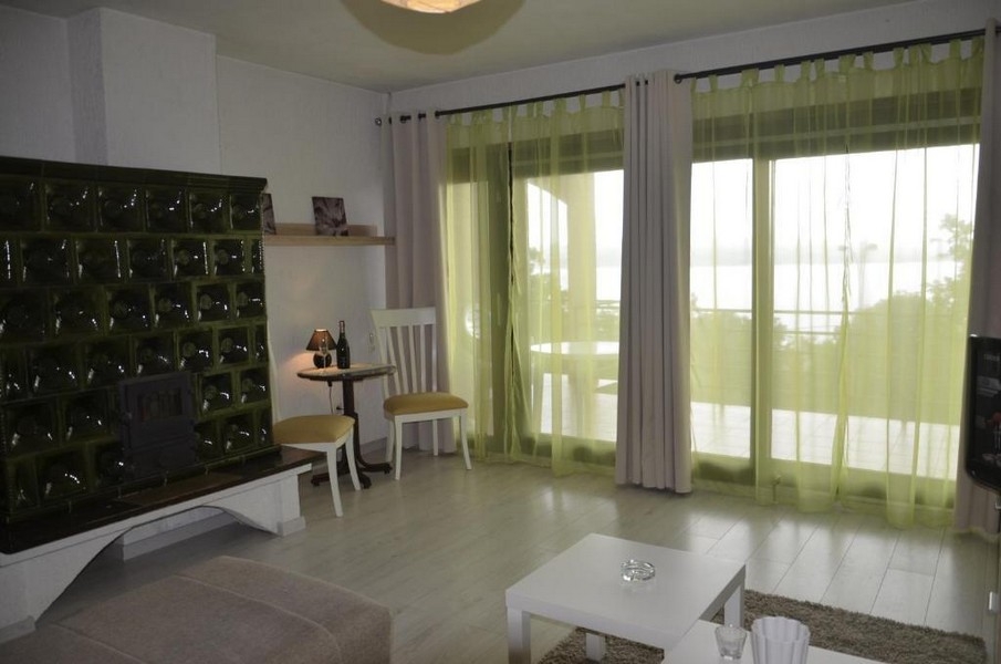 Wohnraum mit Kachelofen und großen Terrassentüren in Crikvenica