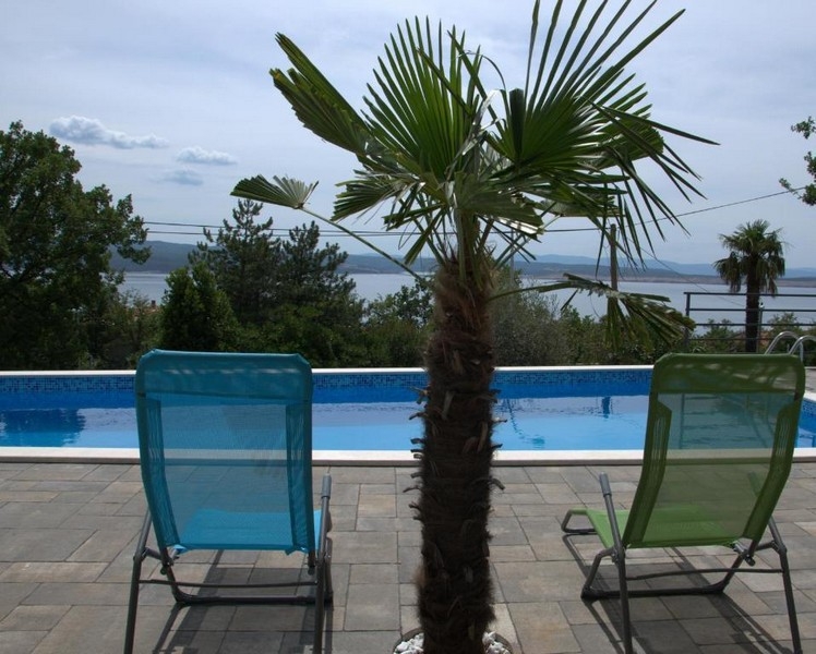 Pool mit Sonnenliegen und Palme in Crikvenica