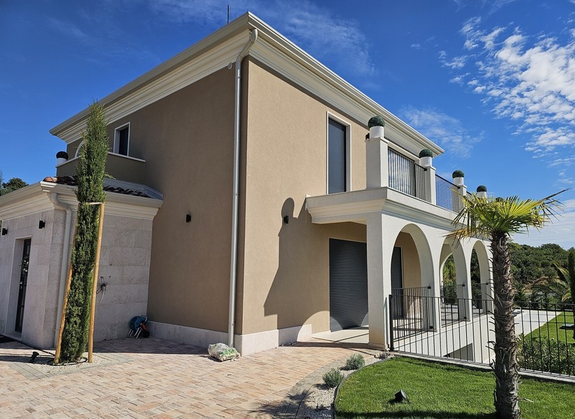Außenansicht der Villa mit Arkaden und Palmen