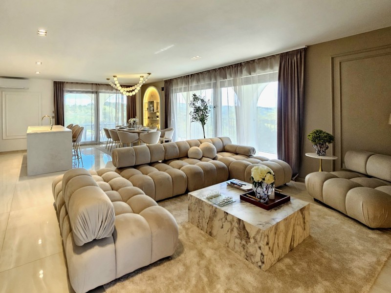 Wohnzimmer mit Sofalandschaft und Marmorboden