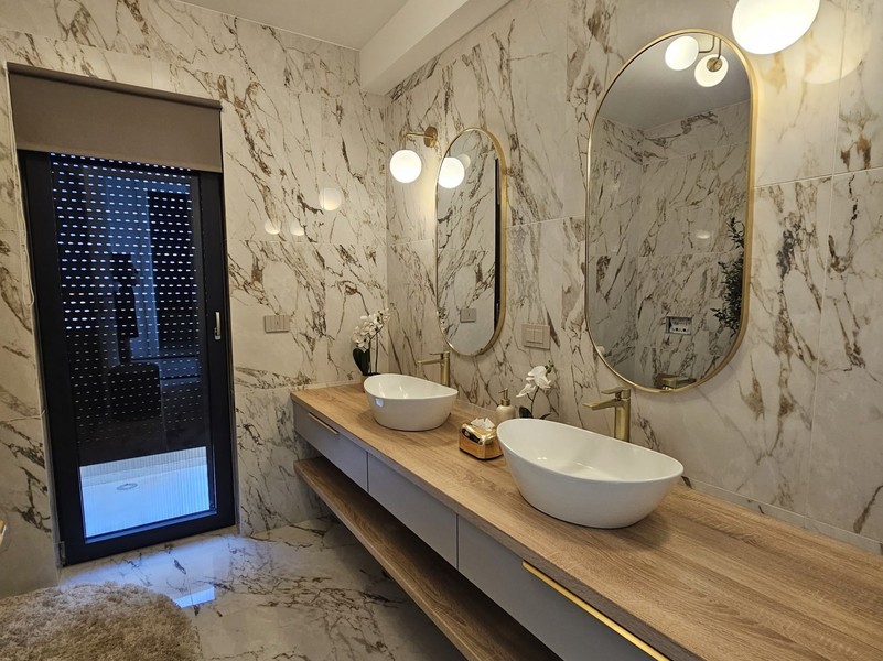 Badezimmer mit Marmorwänden und Aufsatzwaschbecken