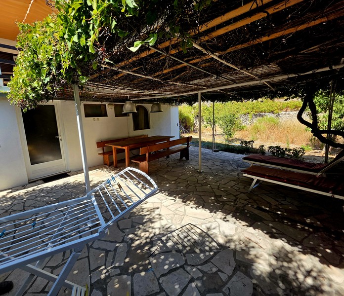 Schattige Terrasse mit Natursteinboden vor dem Haus