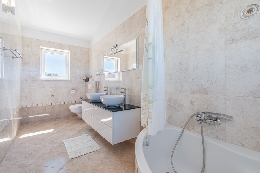 Badezimmer mit Badewanne und zwei Waschbecken bei Porec