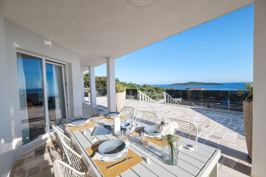 Überdachte Terrasse mit Esstisch am Pool