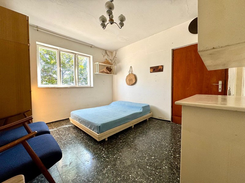 Zimmer mit Bett und großem Fenster