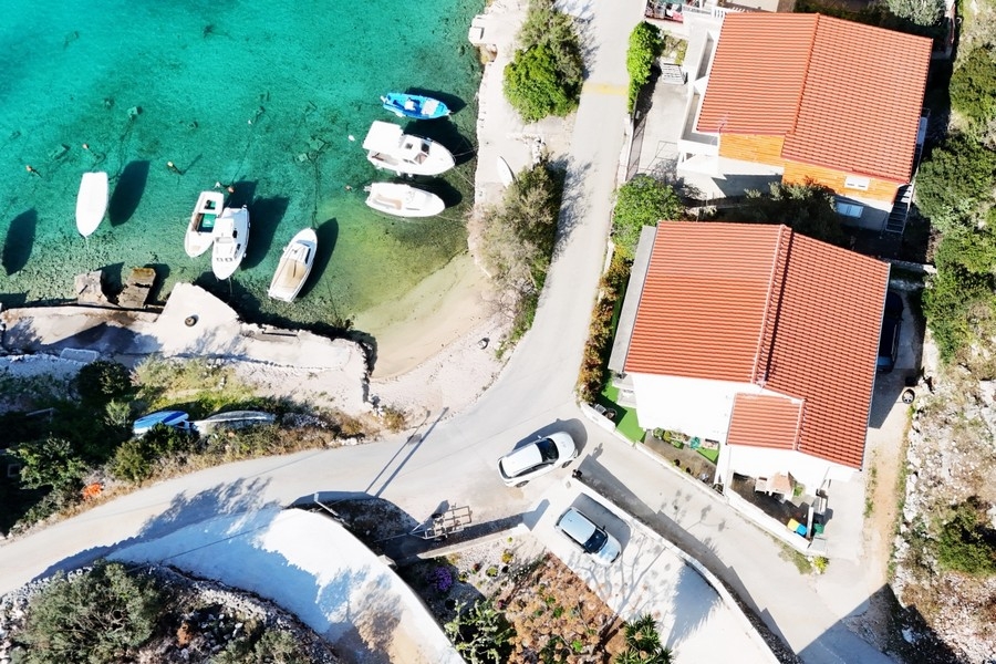 Luftbild der Bucht mit Booten und dem Haus in erster Reihe