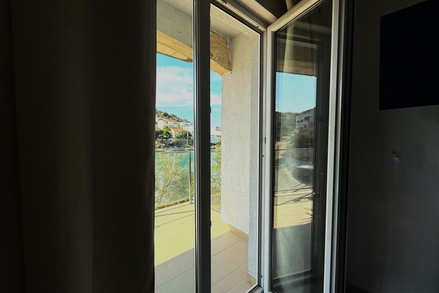 Schlafzimmer mit bodentiefem Fenster und Blick auf die Bucht