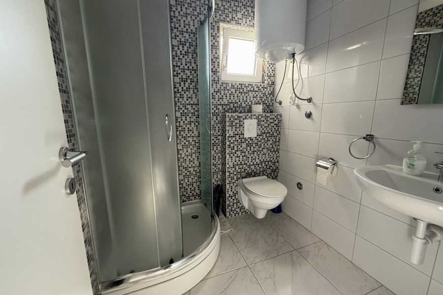 Badezimmer mit Duschkabine, WC und Waschbecken