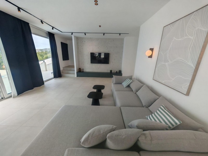 Wohnzimmer mit großer Sofaecke und Fernseher