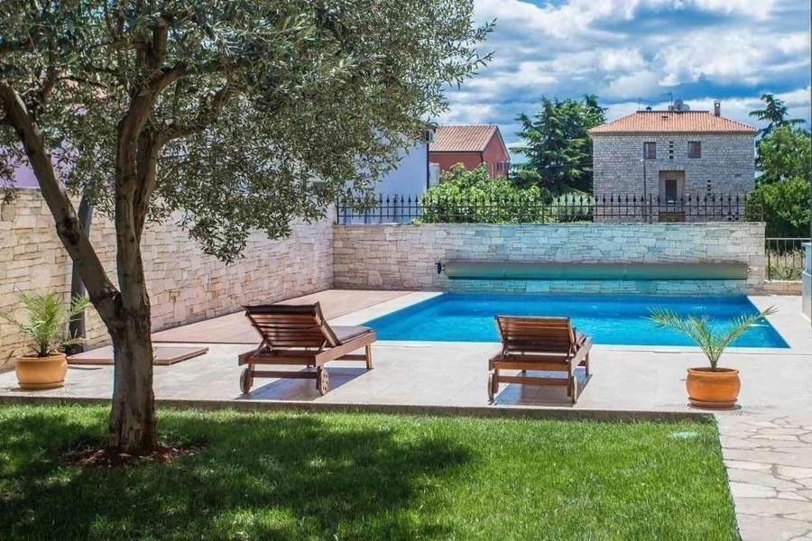 Beheizter Pool mit Sonnenliegen im Garten