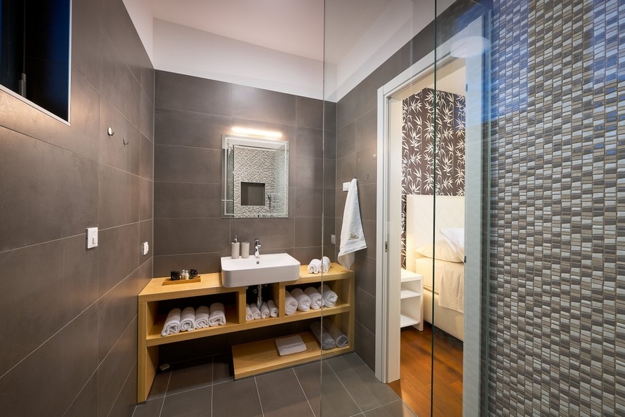 Badezimmer mit Dusche und Waschtisch aus Holz