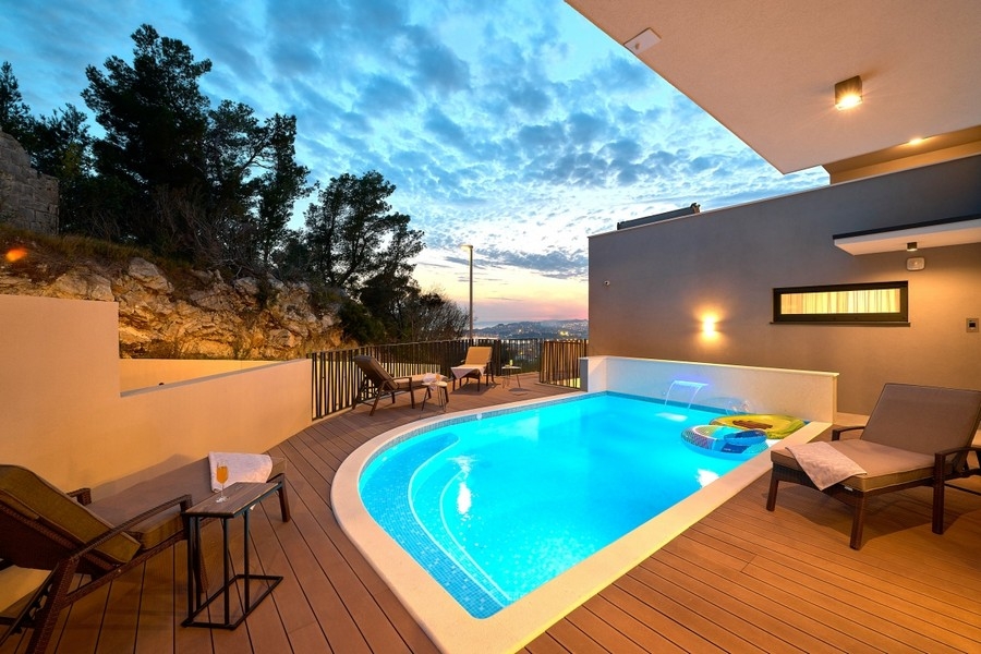 Swimmingpool mit Liegen in der Abenddämmerung