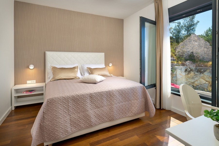 Schlafzimmer mit Doppelbett und großem Fenster