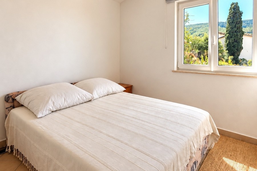 Helles Schlafzimmer mit Doppelbett und Blick ins Grüne