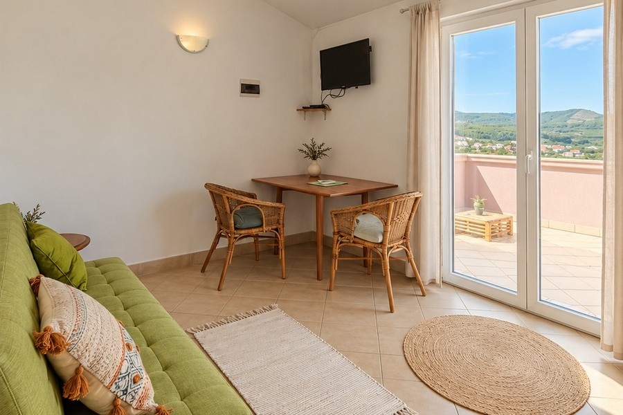 Wohnzimmer eines Apartments mit Sofa und Terrassentür