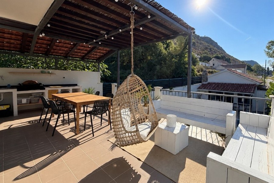 Überdachte Terrasse mit Außenküche und Sitzbereich