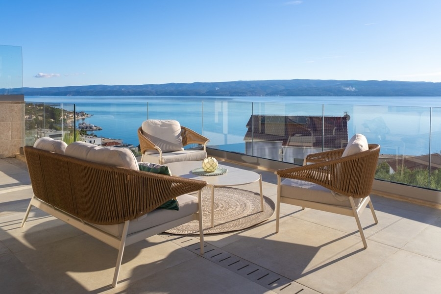 Terrasse mit Loungemöbeln und Blick auf das Meer