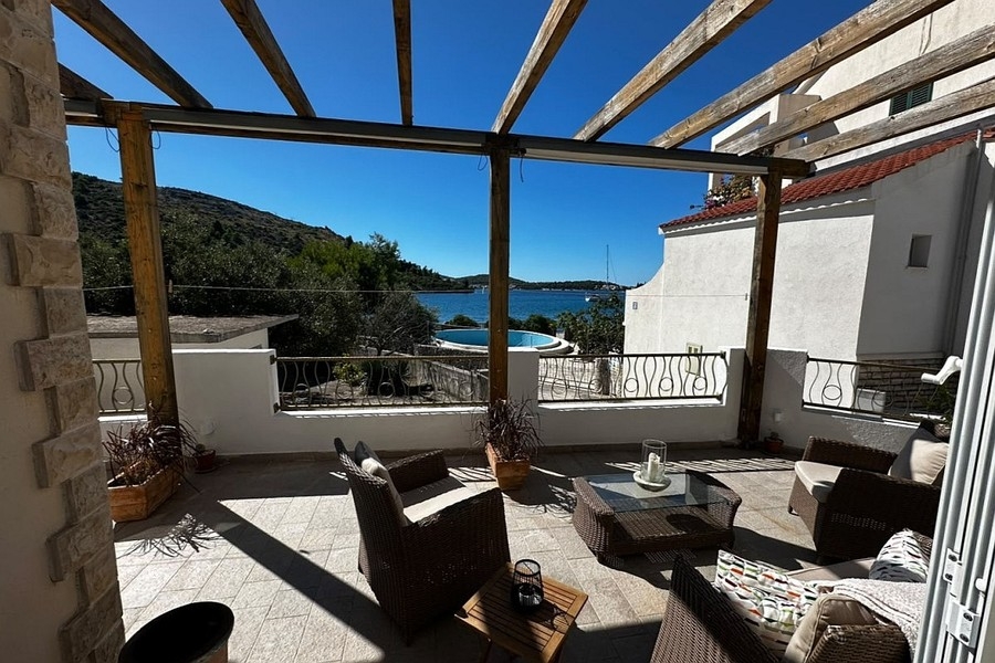 Überdachte Terrasse mit Sitzgruppe und Meerblick