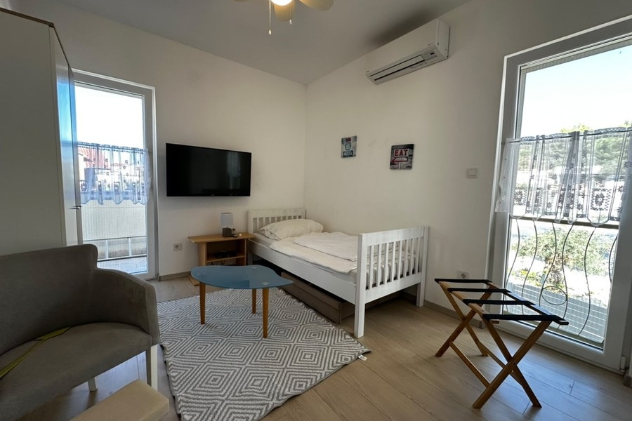 Schlafzimmer mit Einzelbett und Fernseher