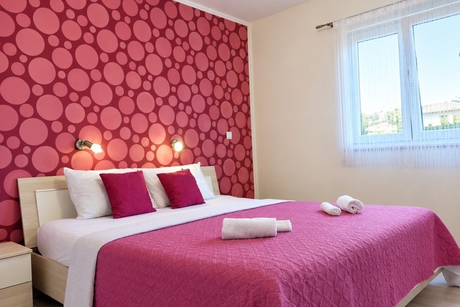 Schlafzimmer mit Doppelbett und gemusterter Wand