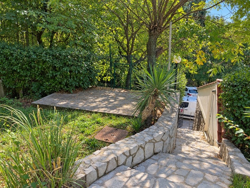 Garten mit Natursteinmauern und Zufahrt