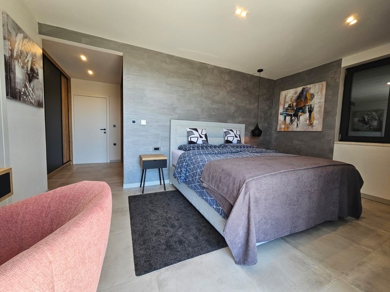Schlafzimmer mit Sessel und Doppelbett