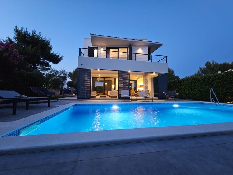 Beleuchtete Villa mit Swimmingpool am Abend