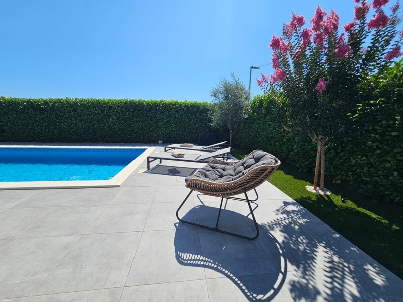 Swimmingpool mit Sonnenfläche und Liegestühlen